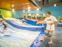 an employee helping a boy flowboarding