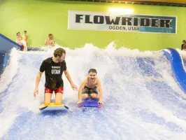 an employee helping a boy on a body board