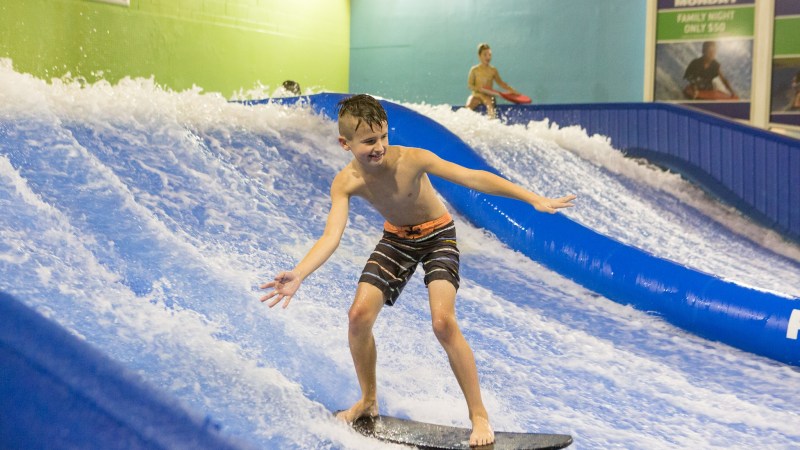 boy surfing indoors on a flowboard