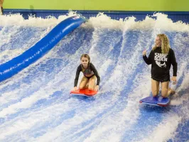 an employee helping a girl at Flowrider