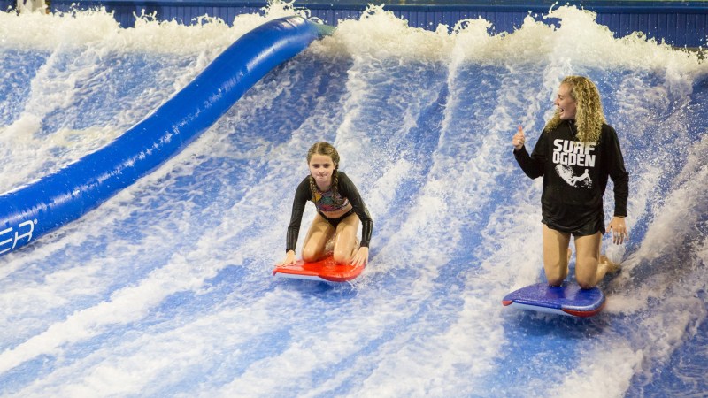 an employee helping a girl at Flowrider